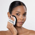 Woman using a Trish McEvoy makeup Eraser on her face against a white background