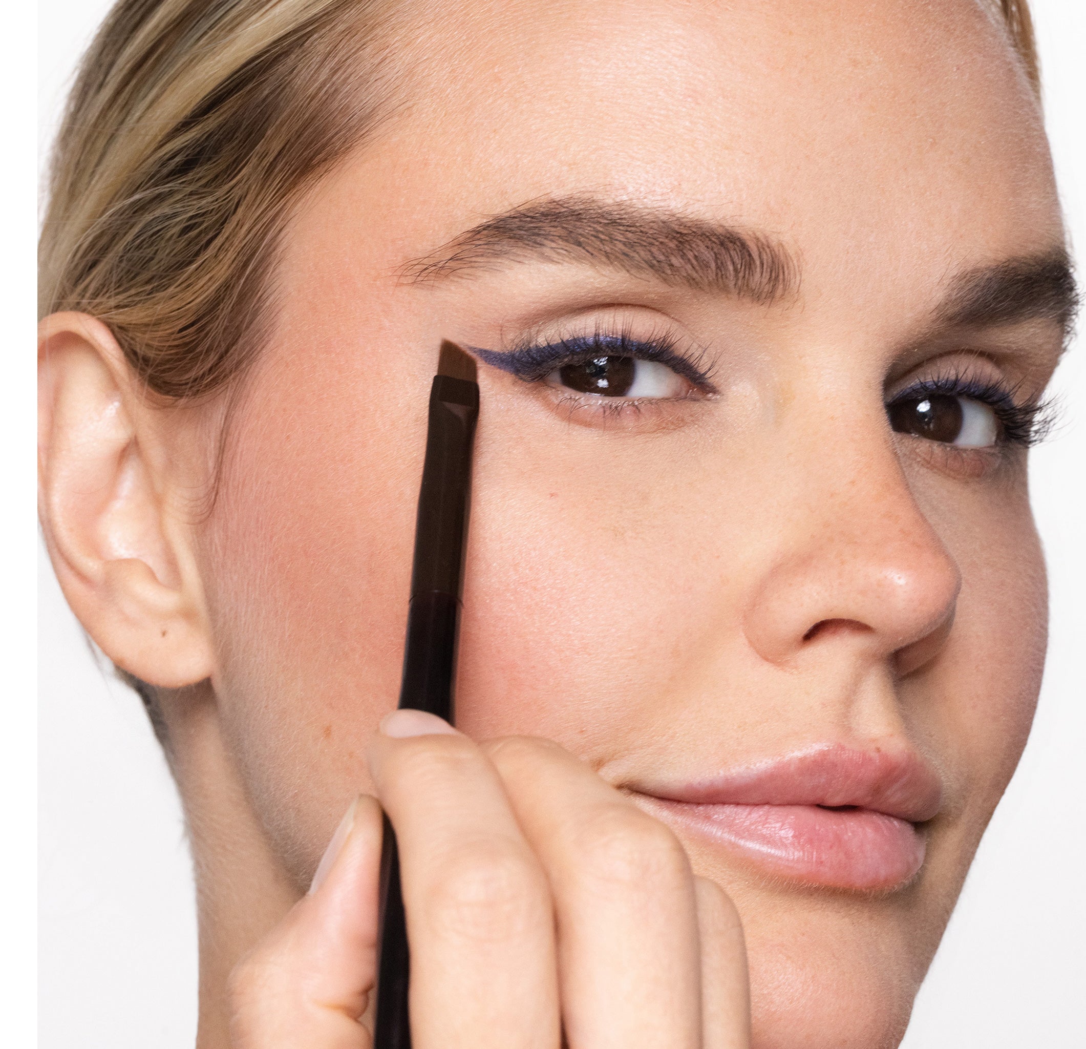 Woman applying eyeliner with Brush 50 Eyeliner