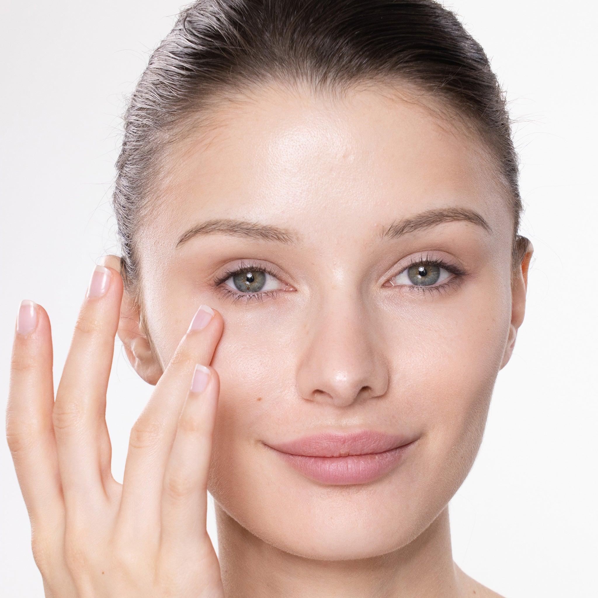 Woman touching her face with a neutral background