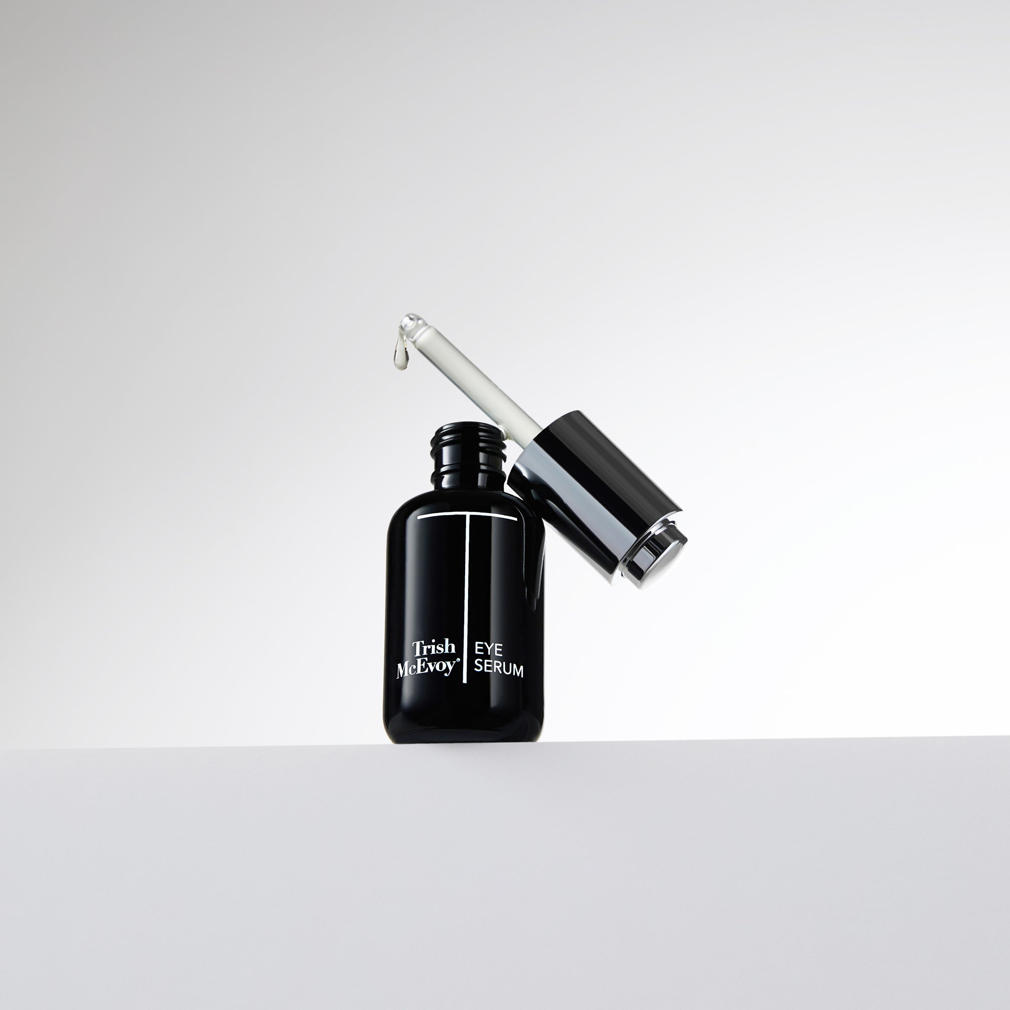 Black eye serum bottle with dropper on a white background