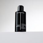 Black bottle of Trish McEvoy Clarifying & Correcting Toner on a light gray background