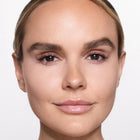 Close-up of a woman's face with a neutral expression on a light background
