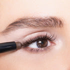 Close-up of an eye with rich color brown eyeliner being applied