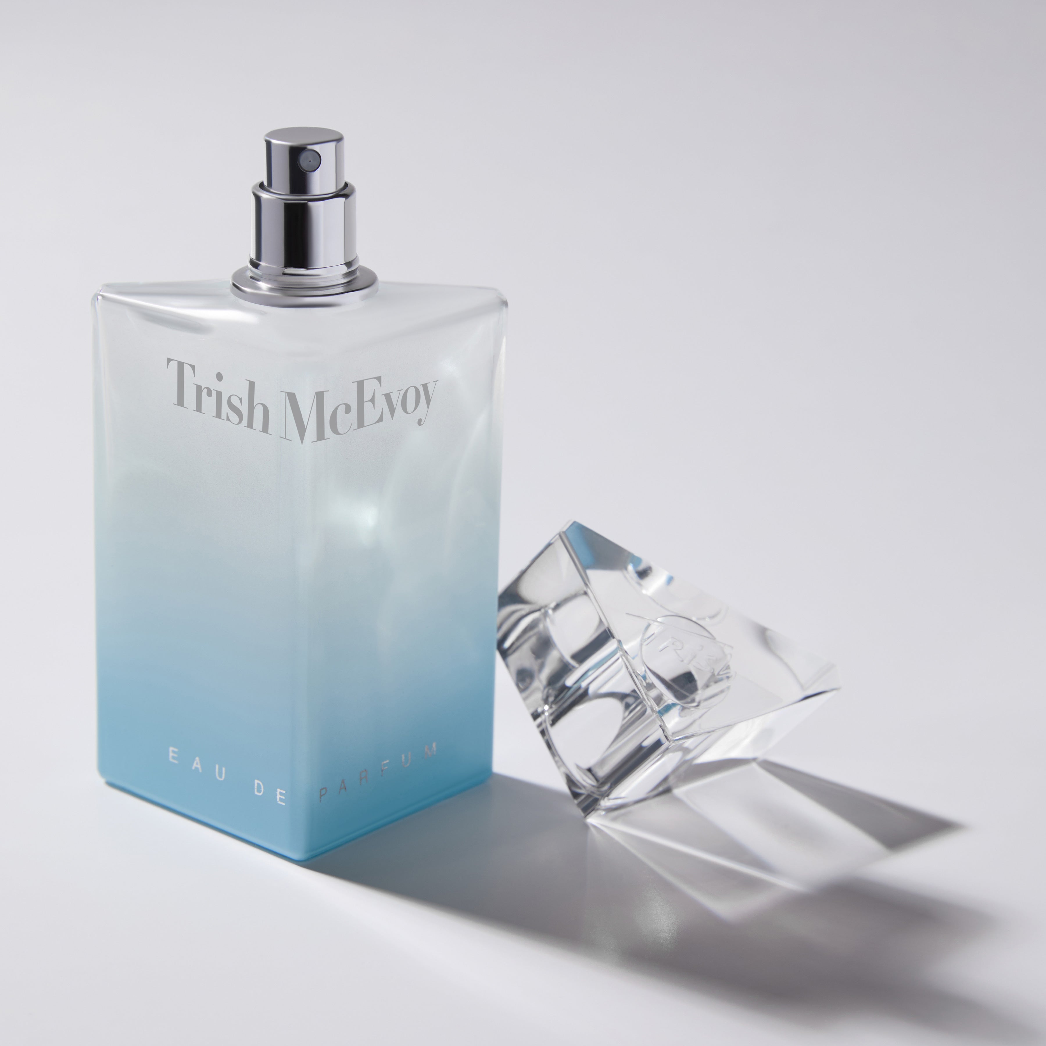 Trish McEvoy perfume bottle with a glass on a light gray background