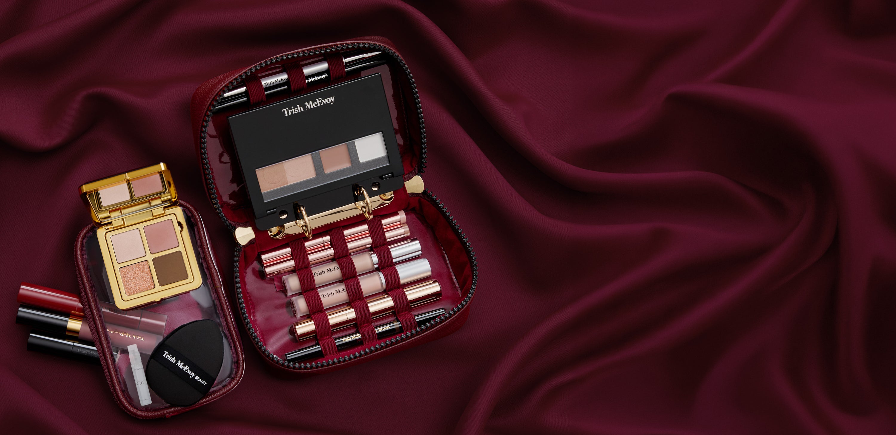 Makeup set with lipsticks and eyeshadows on a burgundy fabric background