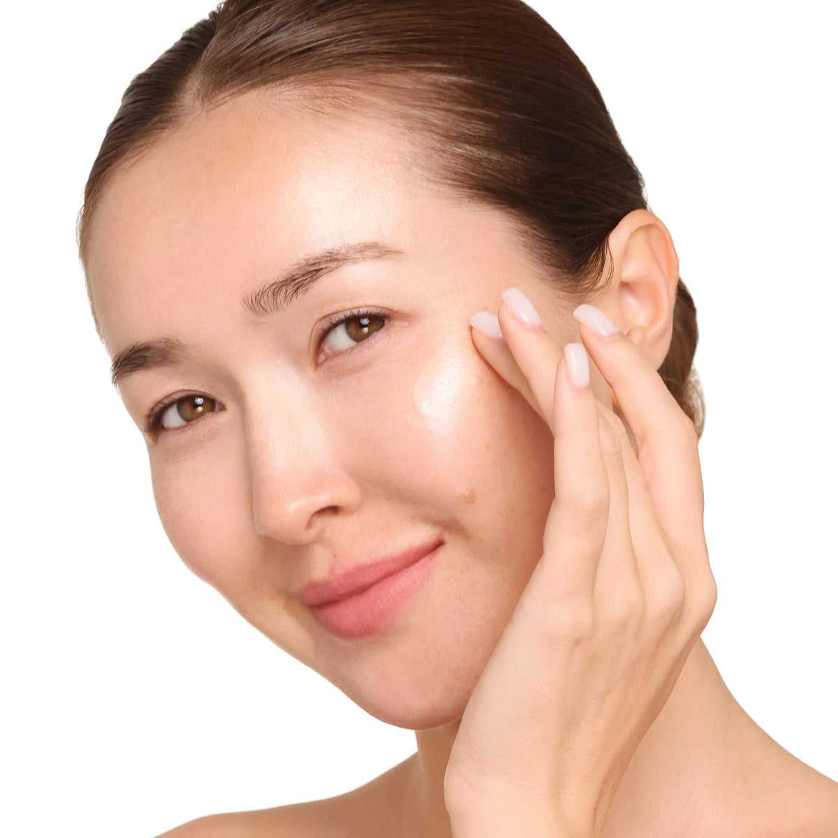 Woman applying skincare product to her face with a clear background