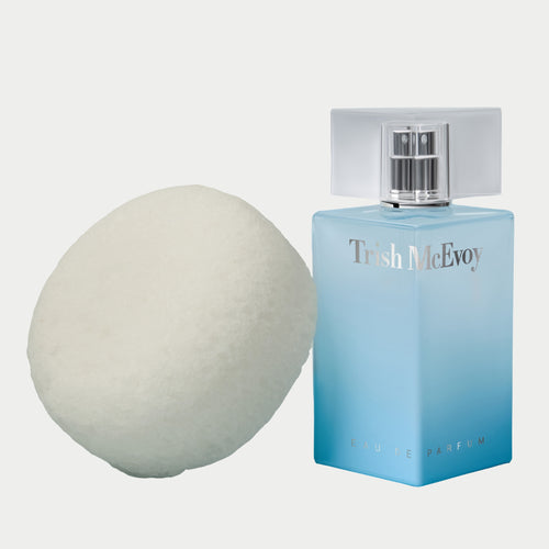 Blue Trish McEvoy no. 8 perfume bottle next to a sexy 9 sponge on a white background