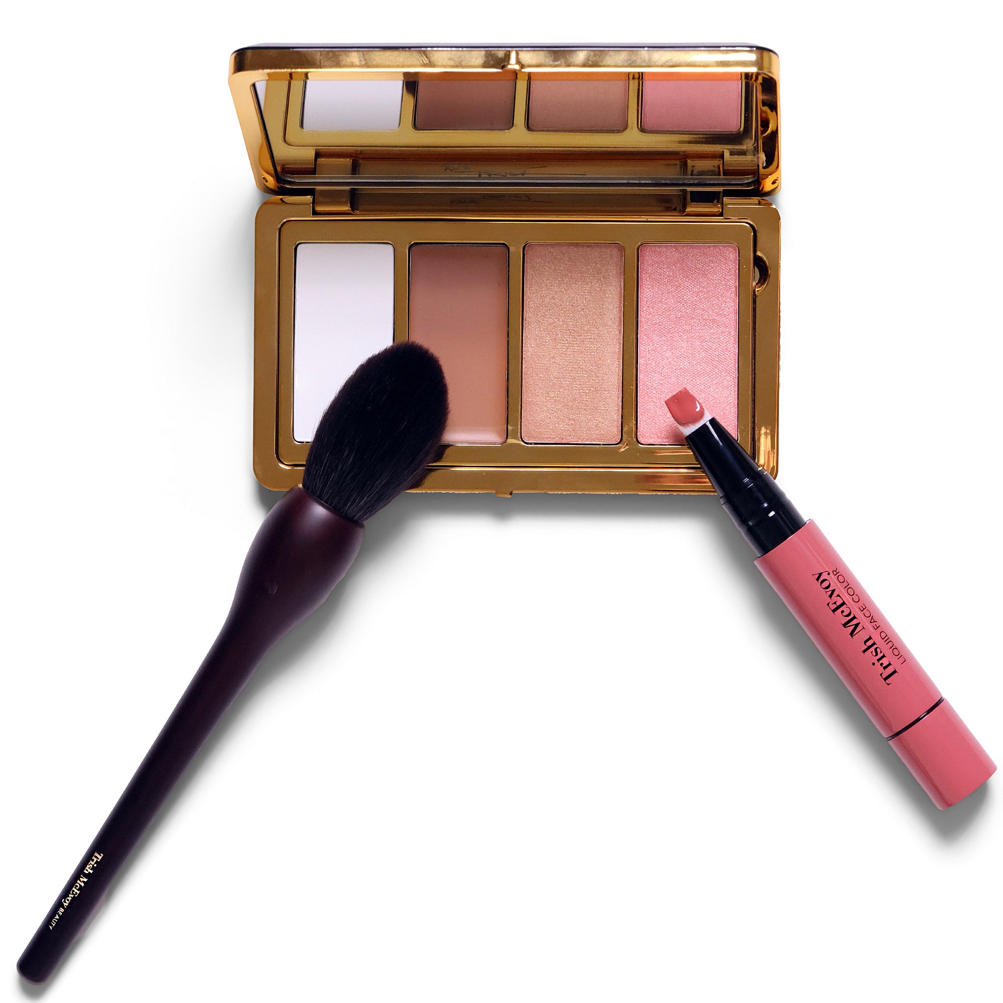 An open gold makeup palette with four blush-toned pans, a pink lip product tube, and a dark makeup brush on a white background.