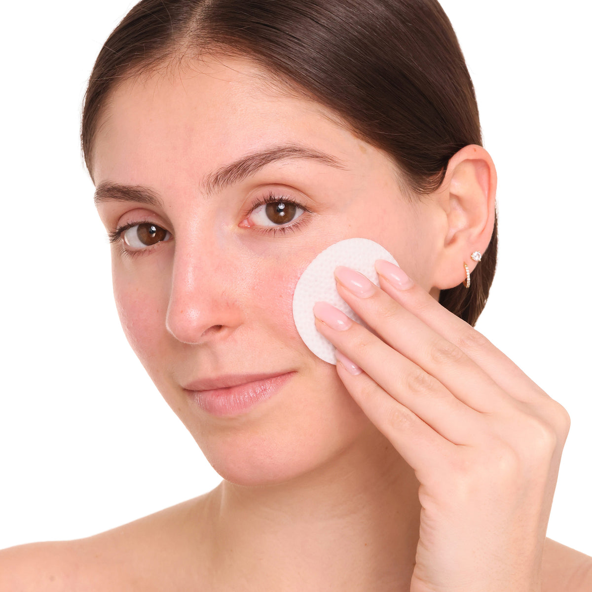 woman using skincare facial pad