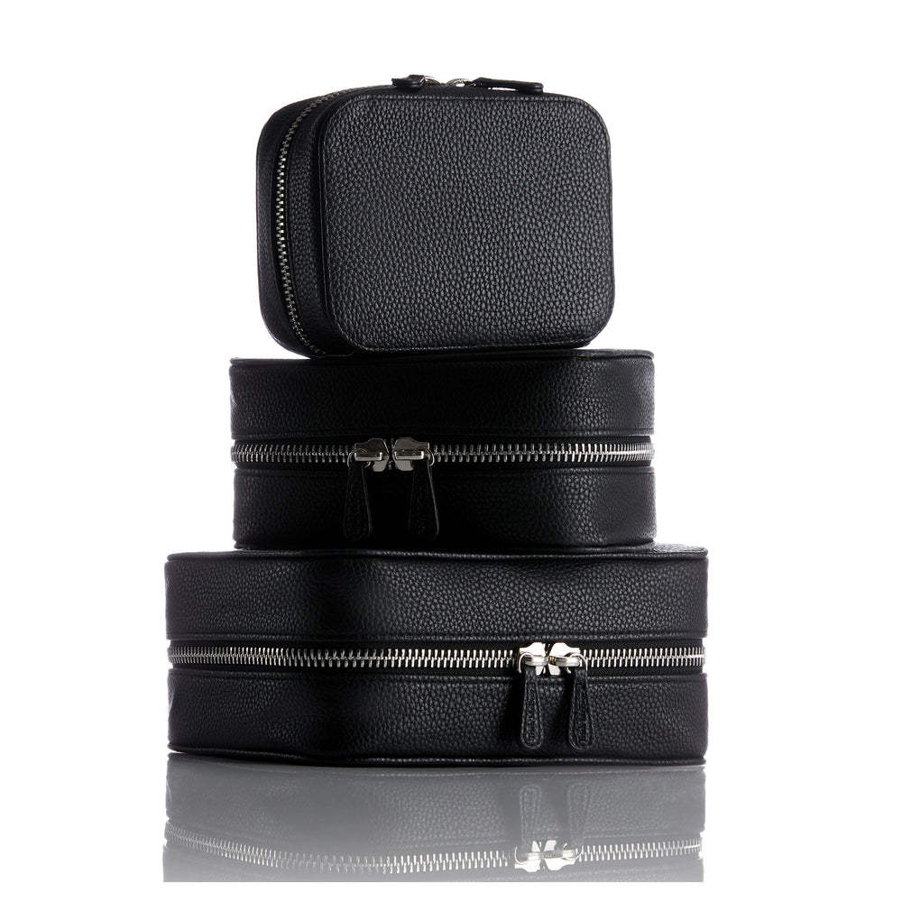 Set of three black leather planners  with silver zippers on a white background