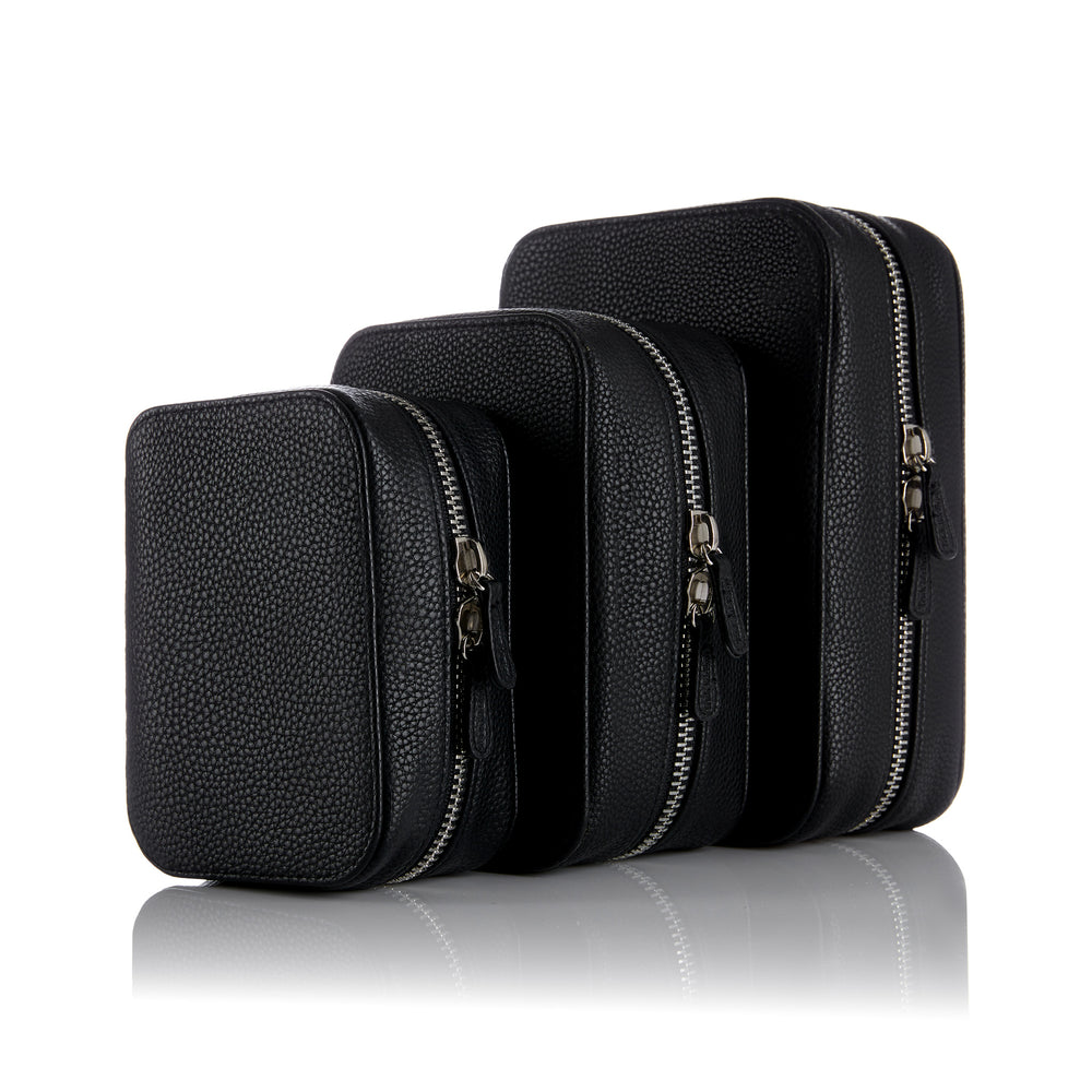 Set of three black leather planners  with silver zippers on a white background