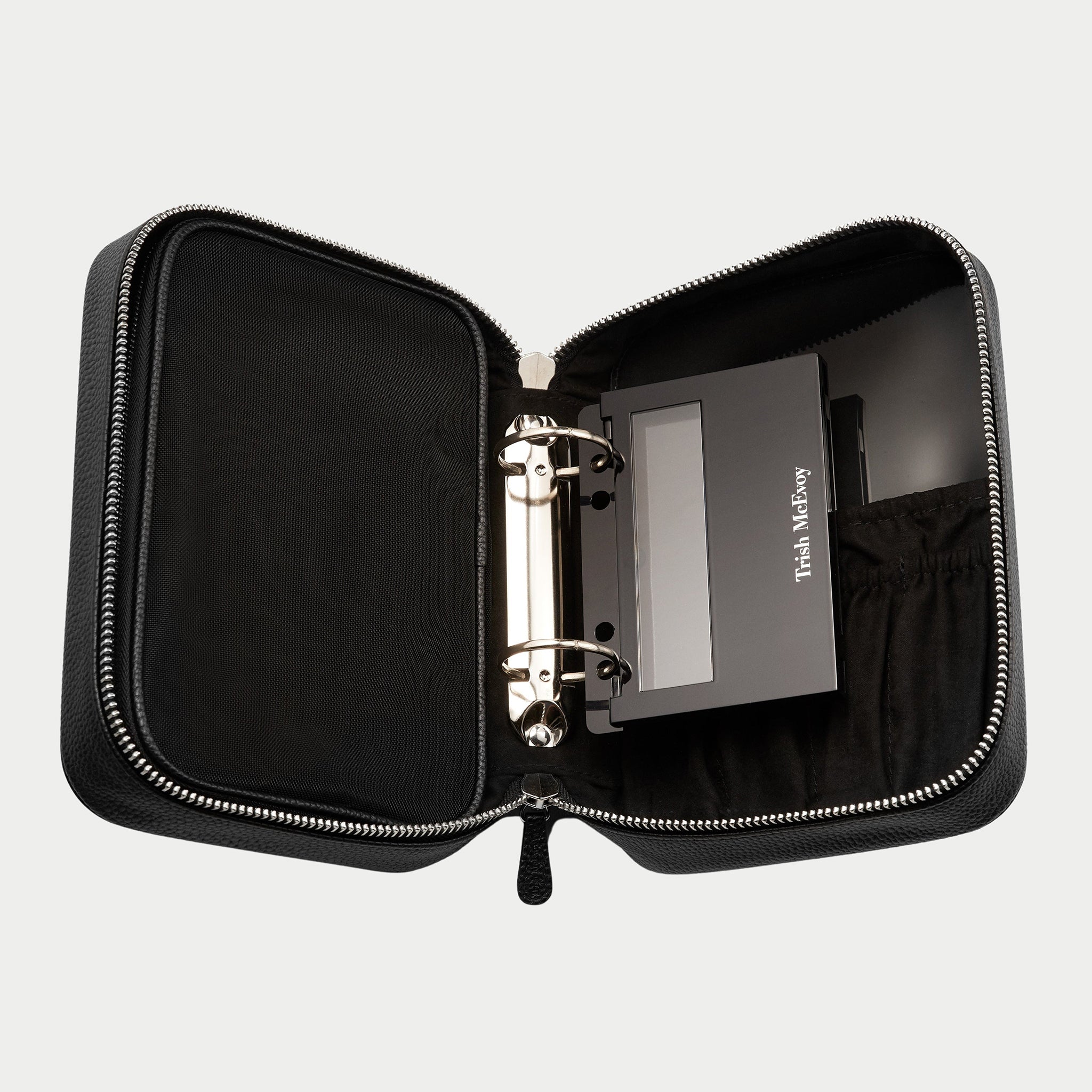 Black leather travel case with zipper on a light gray background