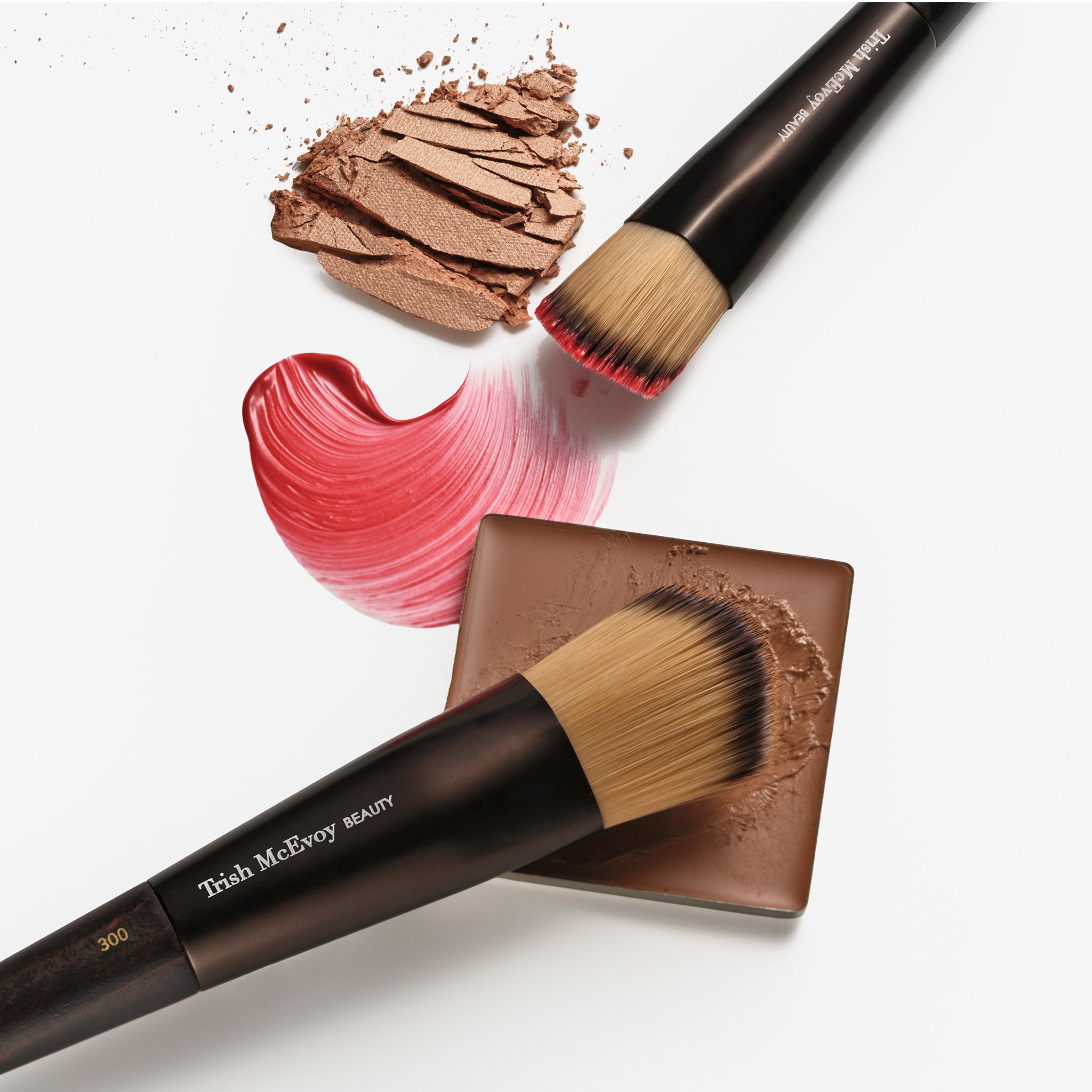 Makeup brushes and brown powder on a white background