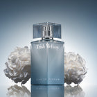 Trish McEvoy Eau de Parfum bottle with white flowers on a reflective surface