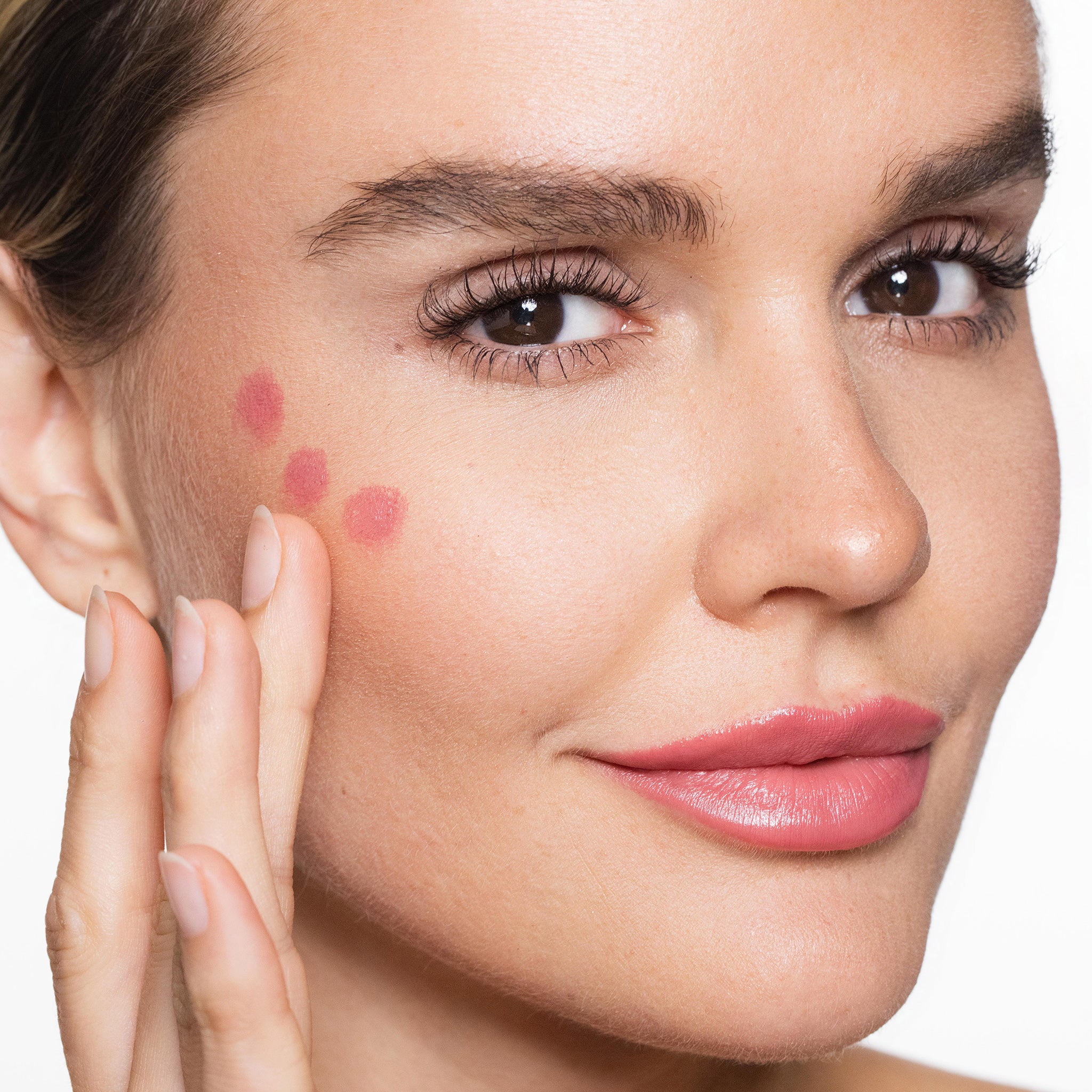 Close-up of a woman's face applying essential pencil  