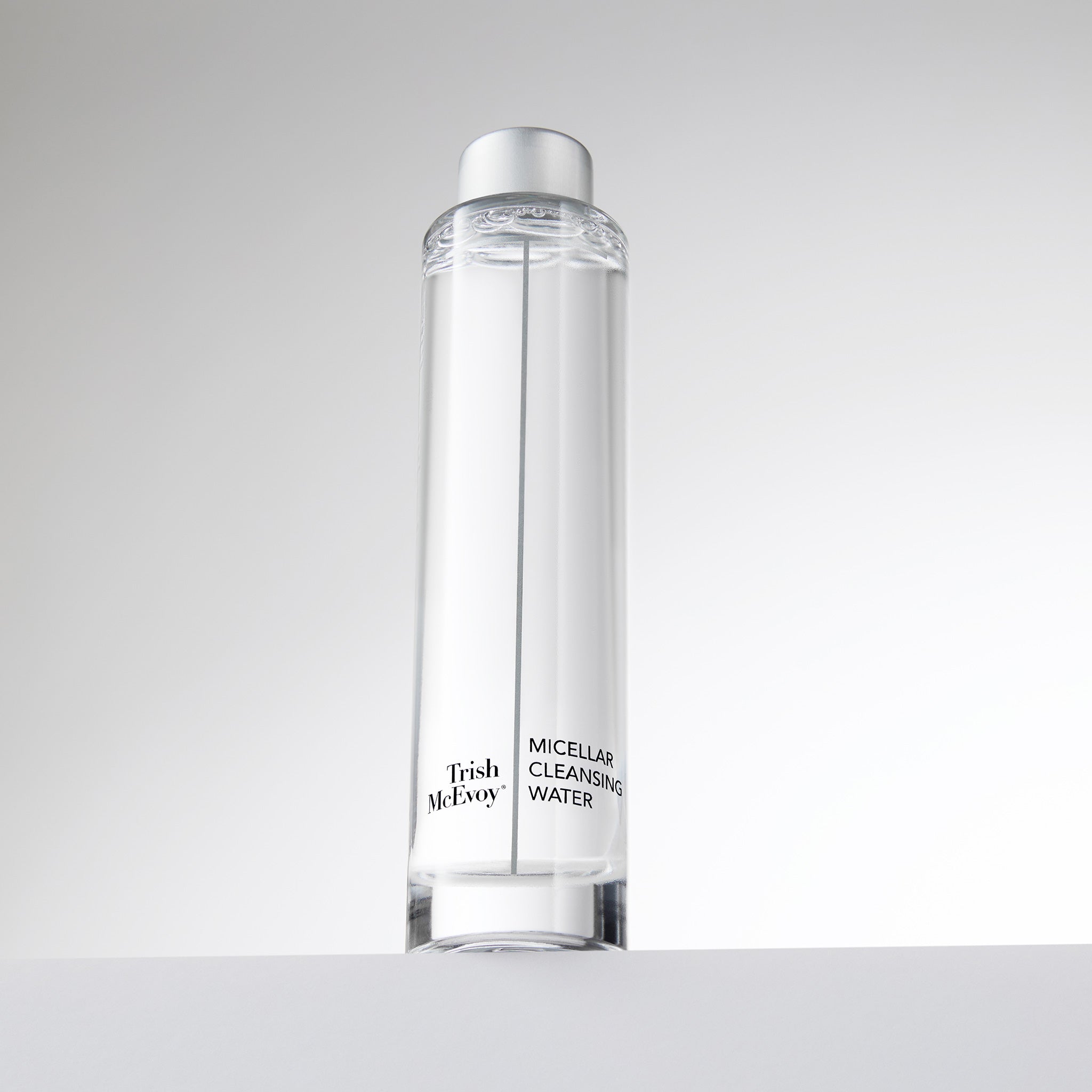 Clear bottle of Trish McEvoy Micellar Cleansing Water on a light gray background