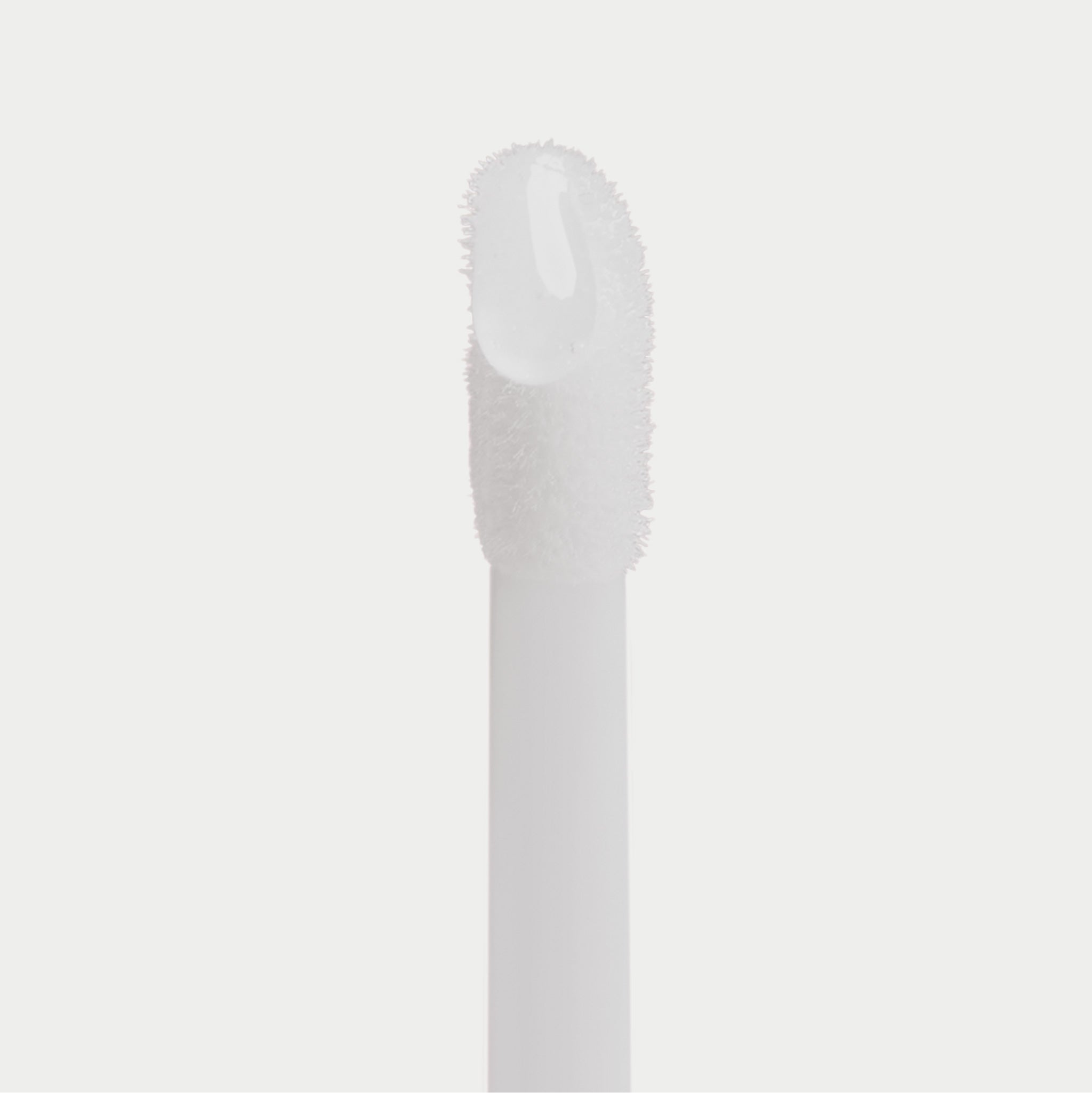 A close-up of a white cosmetic applicator wand with a clear, glossy gel or liquid product swirled on the tip, set against a solid light gray background.