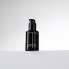 Black bottle of Trish McEvoy Face Wash on a light gray background