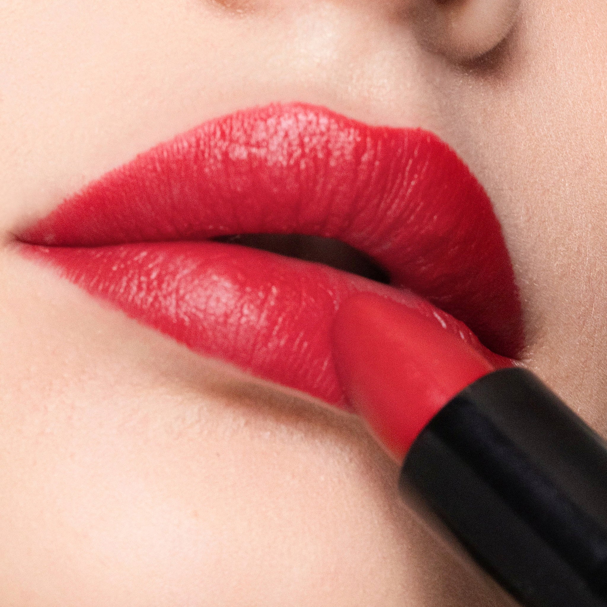 Close-up of a person applying color vixen lipstick with a focus on the lips.