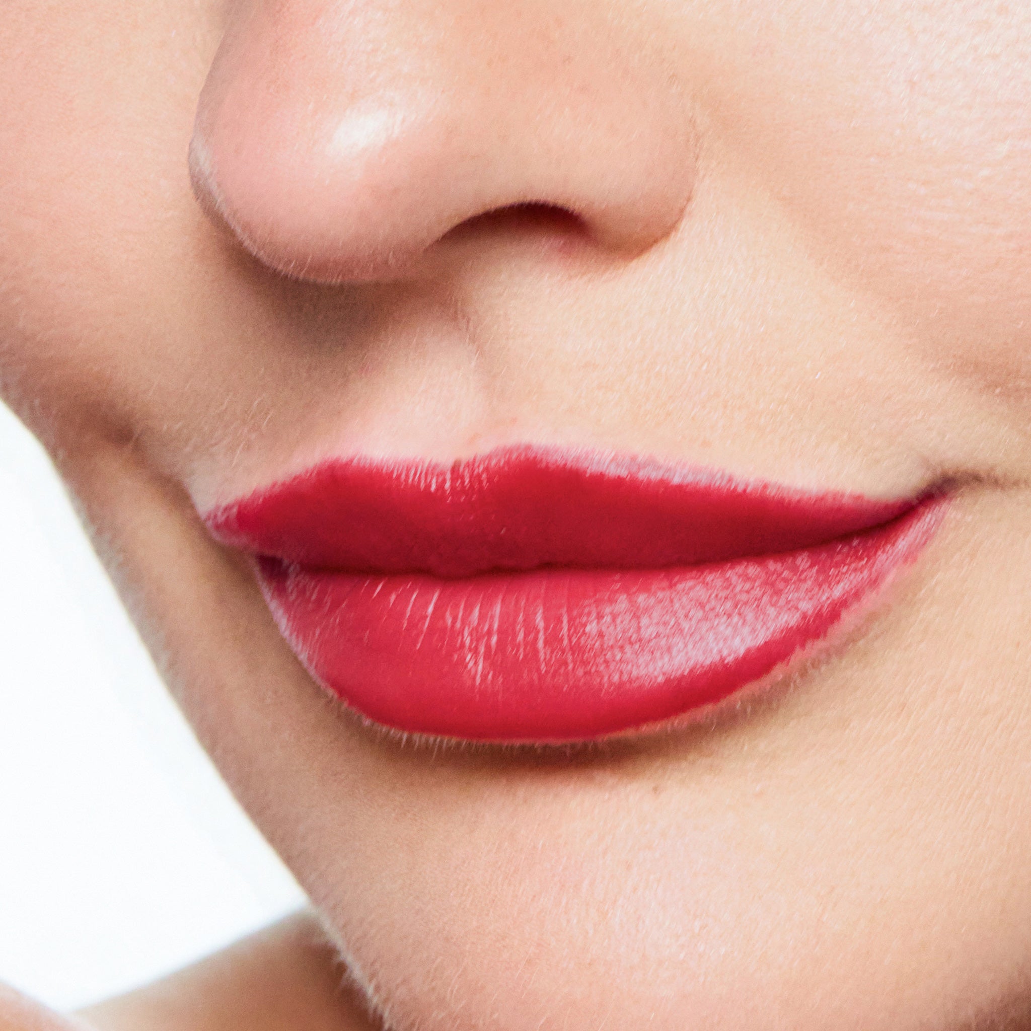 Close-up of a woman's lips with color vixen lipstick on a white background