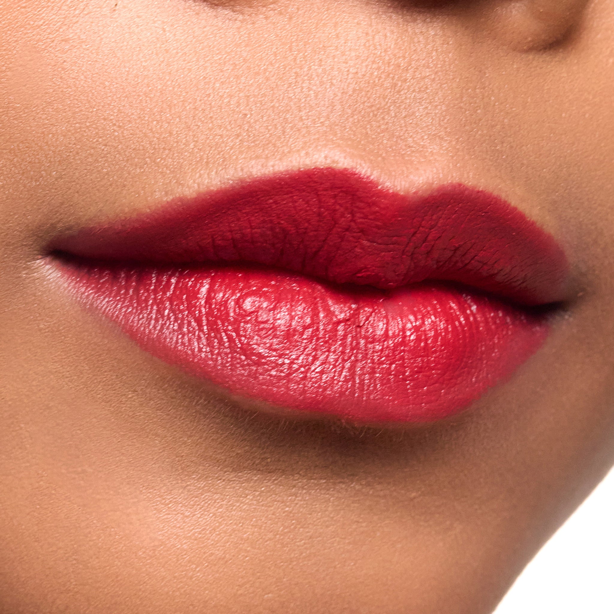 Close-up of a person's lips with color vixen lipstick on a neutral background