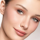Close-up of a woman's face with color pink glow blush