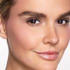 Close-up of a woman's face with color pink glow blush
