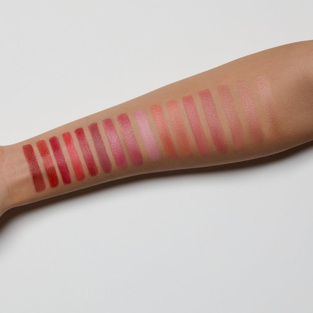 Lipstick swatches on a person's arm with a neutral background