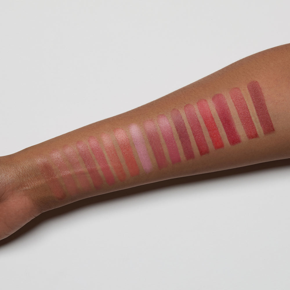 Lipstick swatches on a person's arm with a neutral background