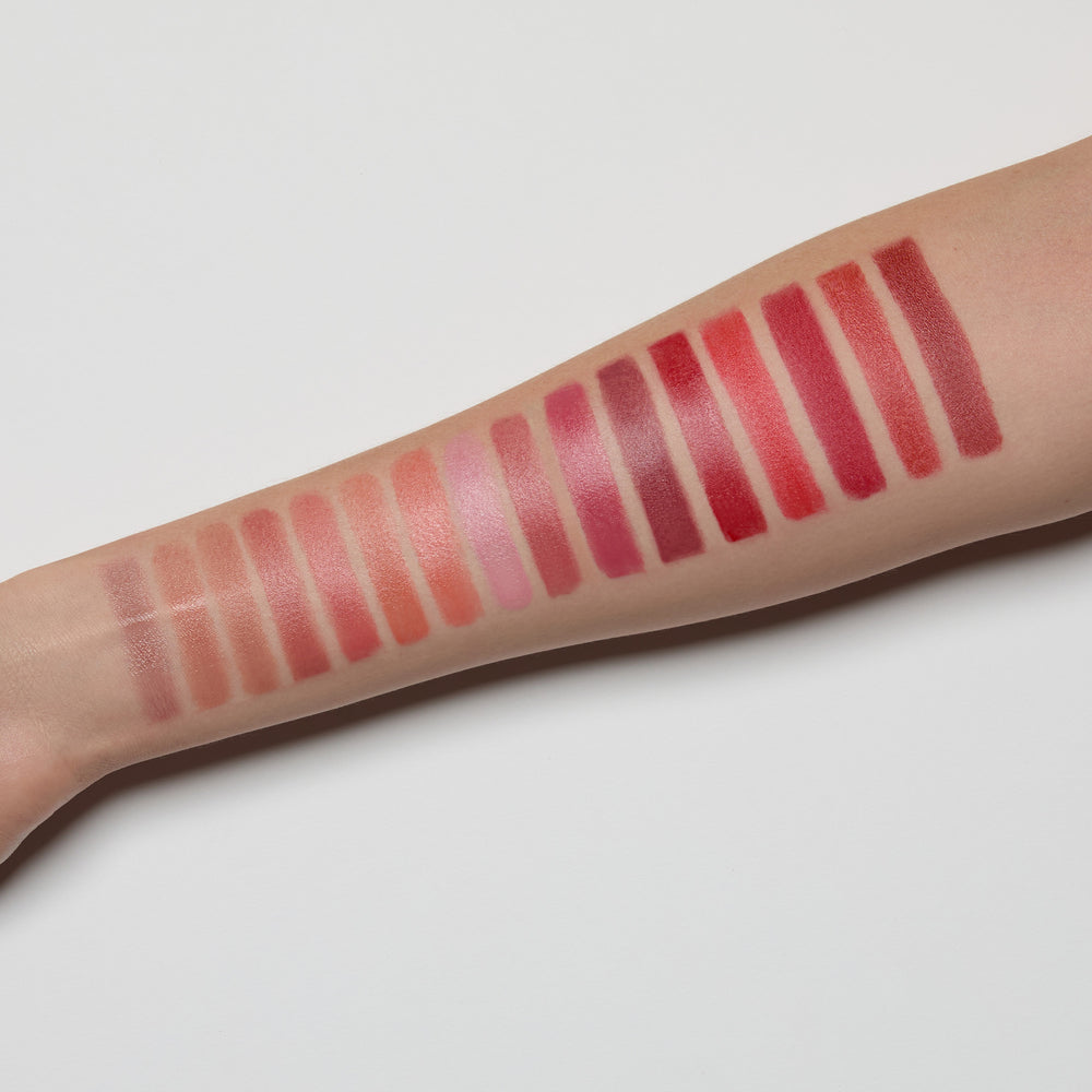 Lipstick swatches on a person's arm with a light gray background