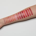 Lipstick swatches on a person's arm with a light gray background