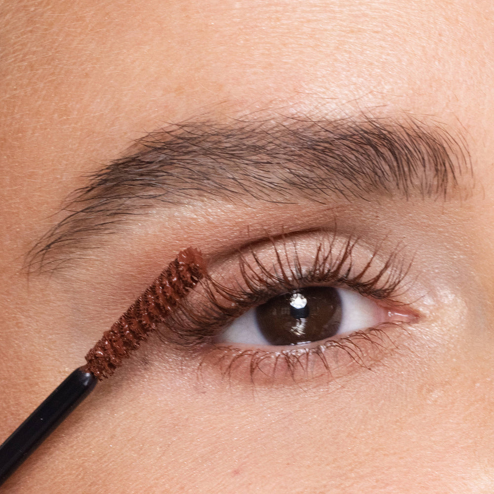 Close-up of an eye with deep aubergine eyeliner being applied