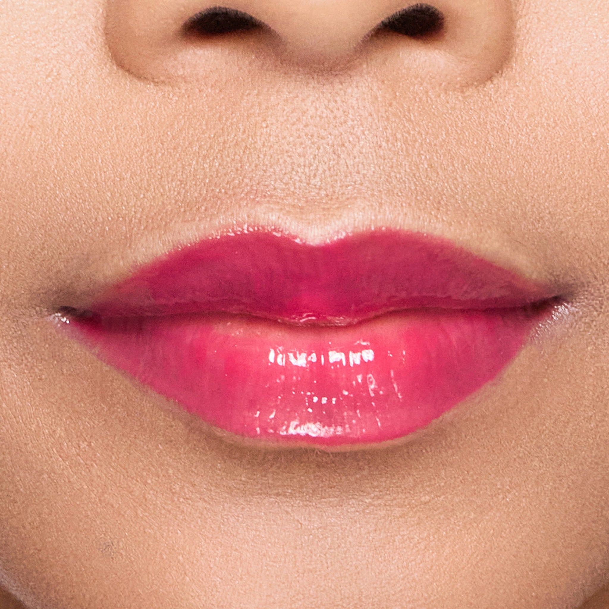 Close-up of a person's lips with color gorgeous lipgloss on a neutral background