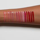 lip gloss swatches on a person's arm with a white background
