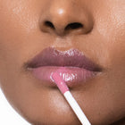 Close-up of a person applying Color timeless lip gloss with a applicator.
