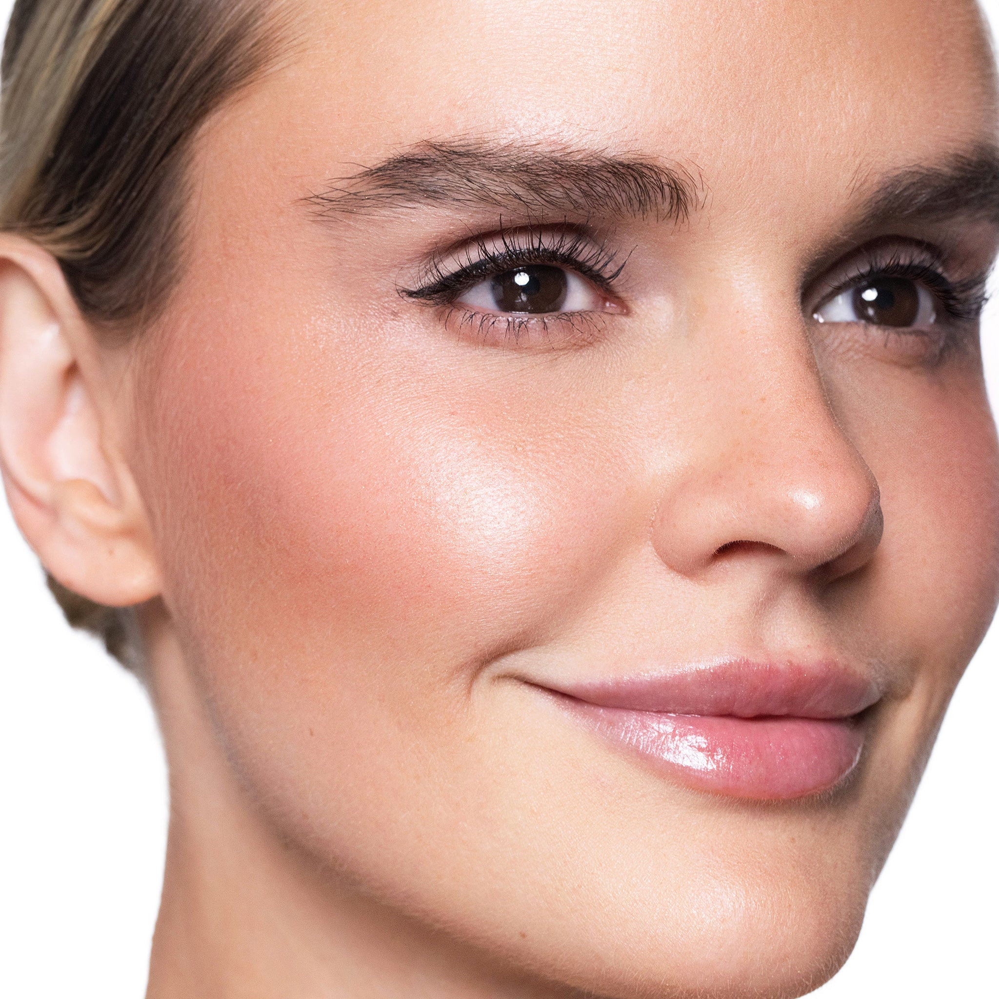 Close-up of a woman's face wearing color glow blush