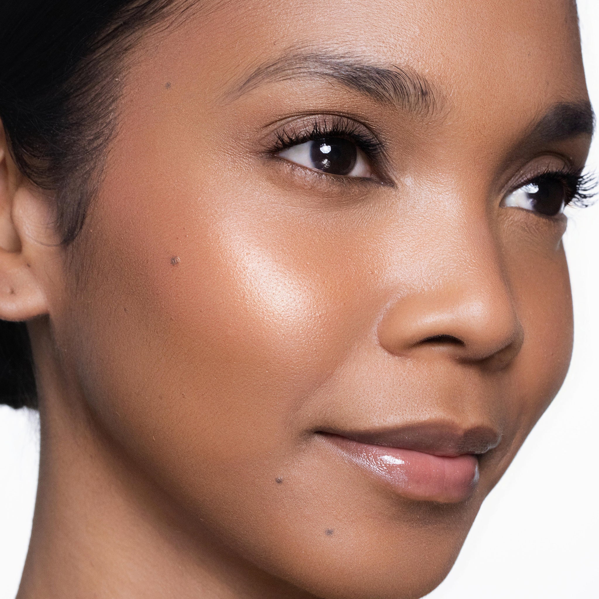 Close-up of a woman's face wearing color glow blush