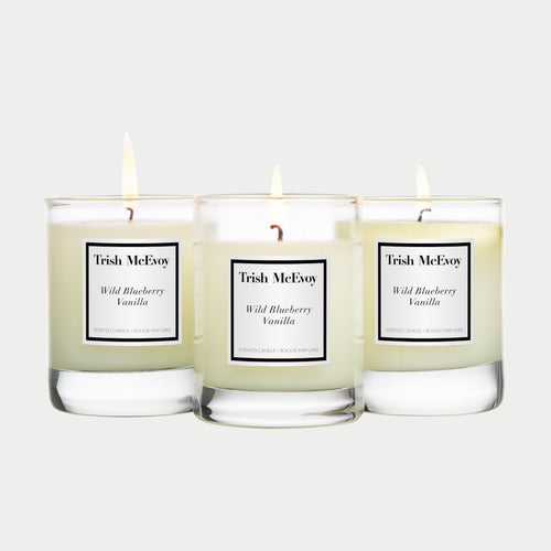 Three Trish McEvoy Wild Blueberry Vanilla candles on a white background