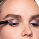 Close-up of a person applying smoky quartz eye makeup