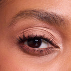 Close-up of a woman's eye with color rose quartz makeup