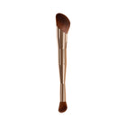 Makeup brush with a gold handle and brown bristle head on a white background