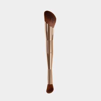 Makeup brush with brown bristle head on a light gray background