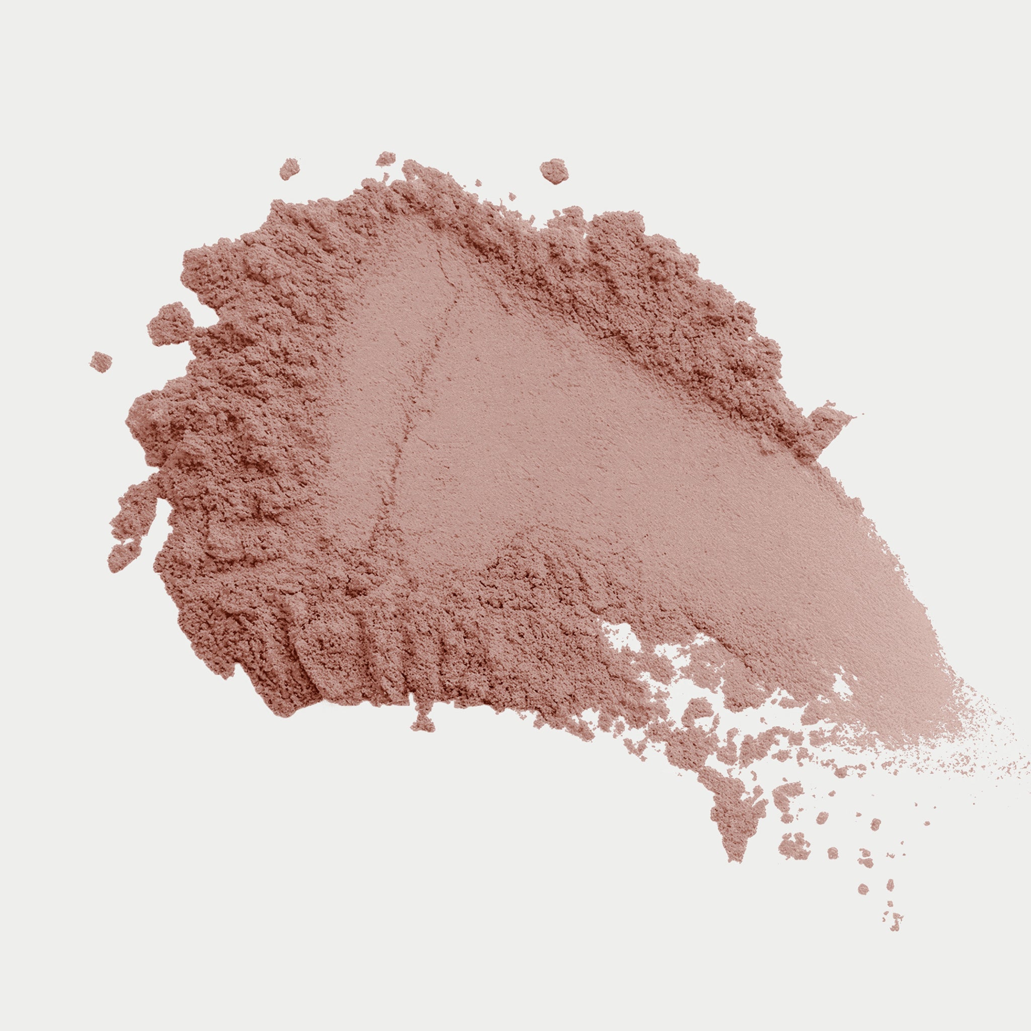 Clump of brown makeup powder on a light gray background