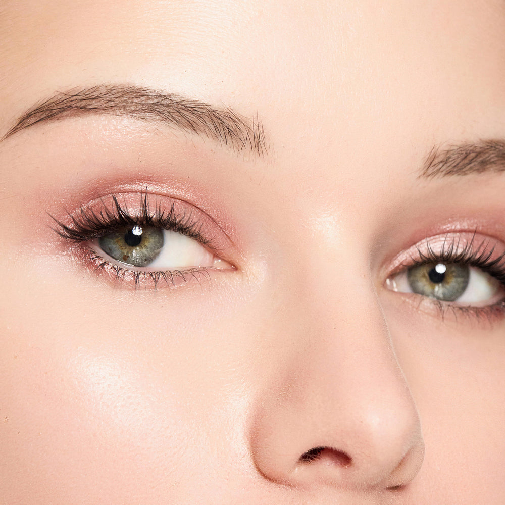 Close-up of a person's eyes with Bliss eyeshadow makeup on a light background