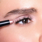 Close-up of a person applying bliss eye shadow to their eye with a pencil.