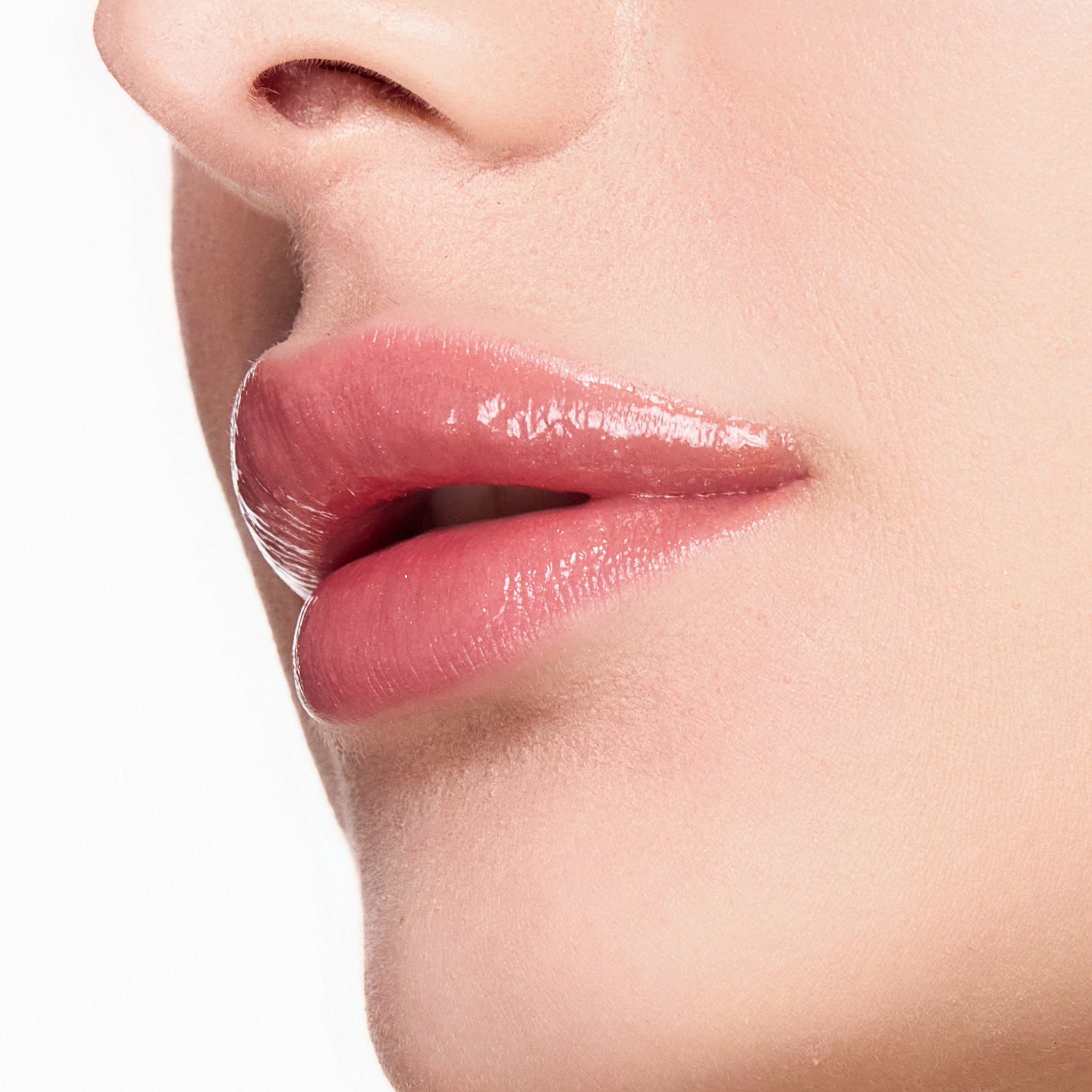 Close-up of a person's lips with color sexy nude lip gloss on a neutral background