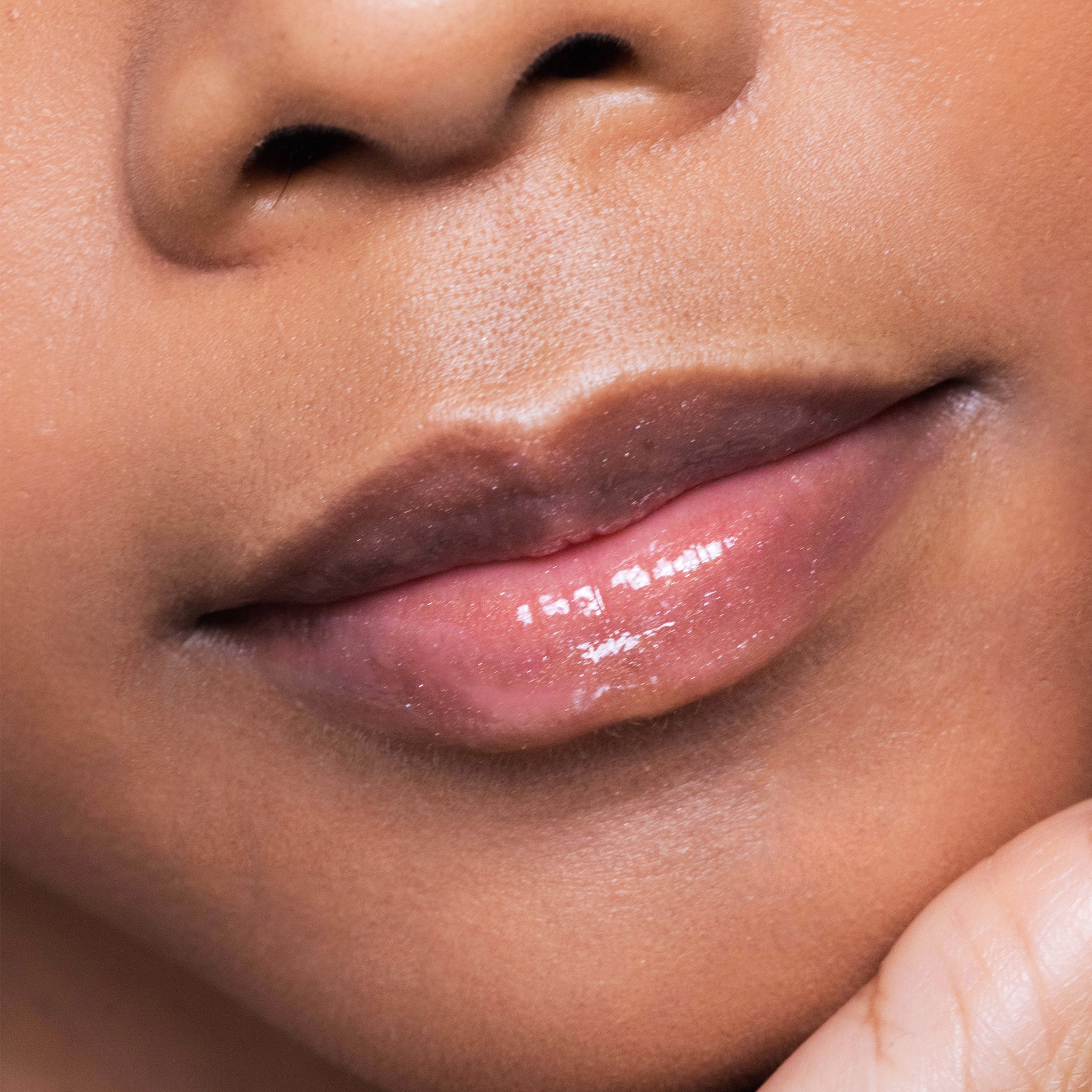 Close-up of a person's lips with a color sexy nude lipgloss