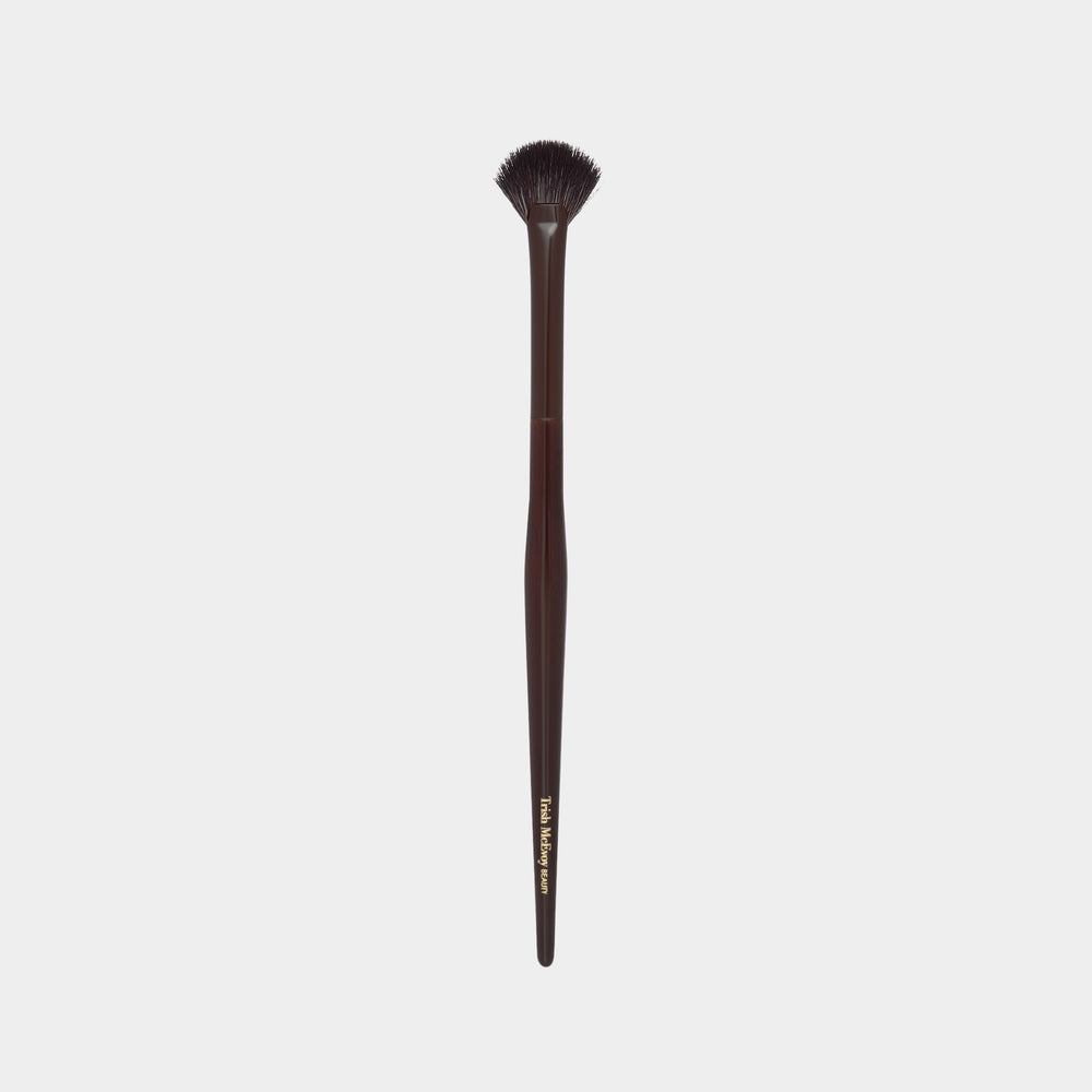 Makeup Mini Fan brush with brown handle and black bristles on a white background