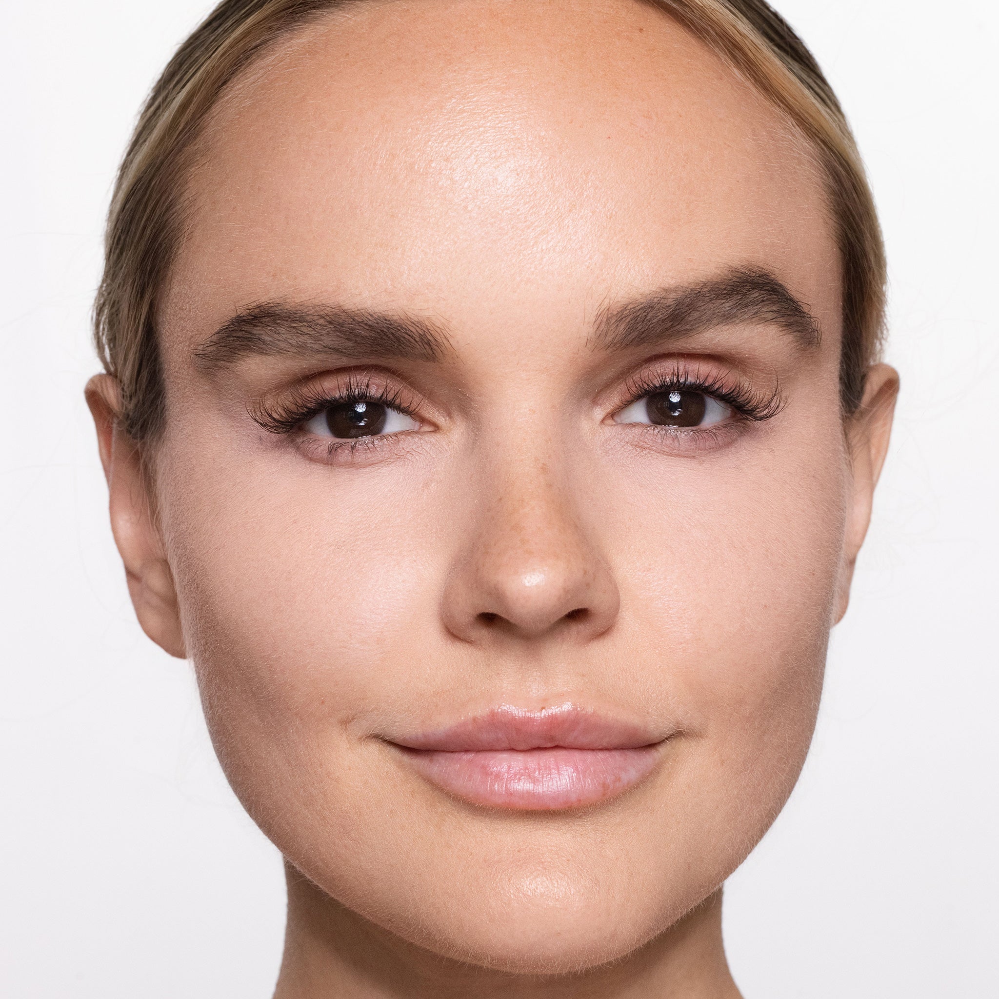 Close-up of a woman's face with a neutral expression on a light background