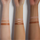 Three arms with horizontal swatches of different shades of instant eye lift on a white background